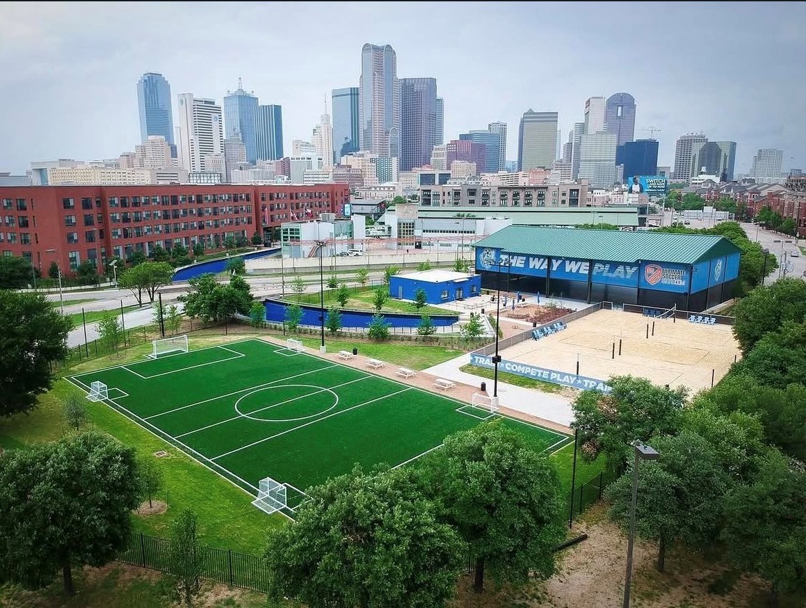 City Futsal Fields – Aerial View City Futsal courts — green turf fields and sand court with the downtown Dallas skyline
